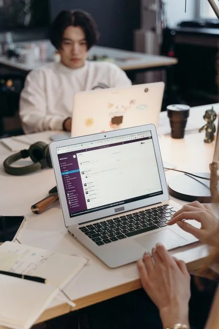 Bureau au style épuré avec ordinateur portable, lunettes et affiche verte de brainstorming pour inspirer de nouvelles idées.